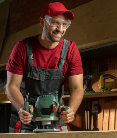 Schreiner fräst Arbeitsplatten Verbindung per Hand mit Oberfräse